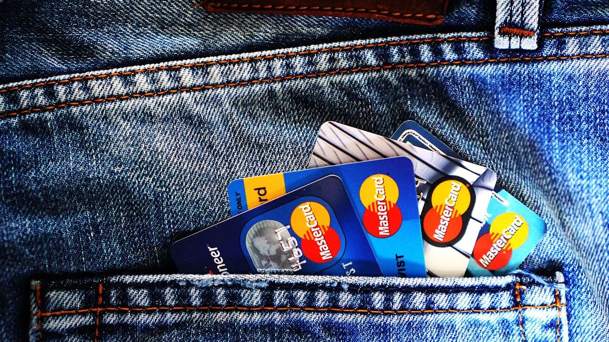 Credit cards tucked into a jeans pocket, illustrating consumer debt